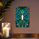 Art deco gothic medallion artwork in deep teal and gold printed on a single switch plate cover by Primal Painter on a brown wall over a shelf with a candle