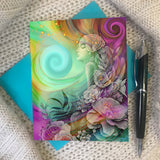 Greeting card featuring artwork of a flourish of colorful flowers surrounding a youthful goddess called Flower Child by Primal Painter