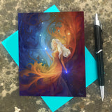 Greeting card featuring art by Primal Painter called Nebula in blue, orange, and red of a goddess with long white hair and swirls of energy against a starry sky with a blue envelope